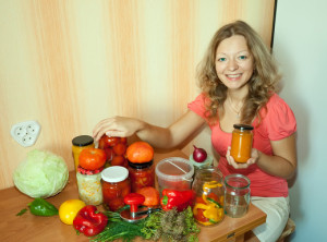 Frau mit Einmachgläsern und Gemüse